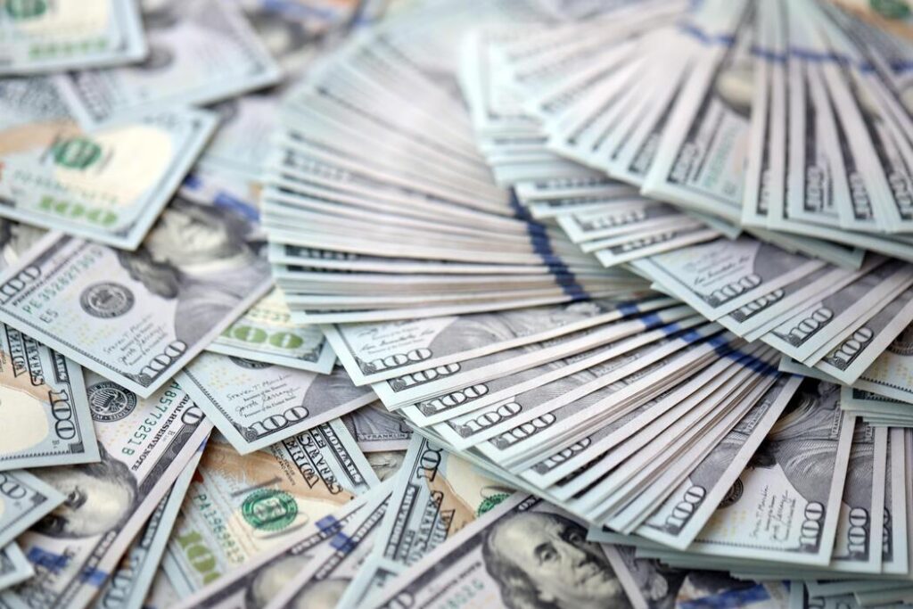 very big amount of us hundred dollar bills huge quantity of united states currency notes on flat table photo